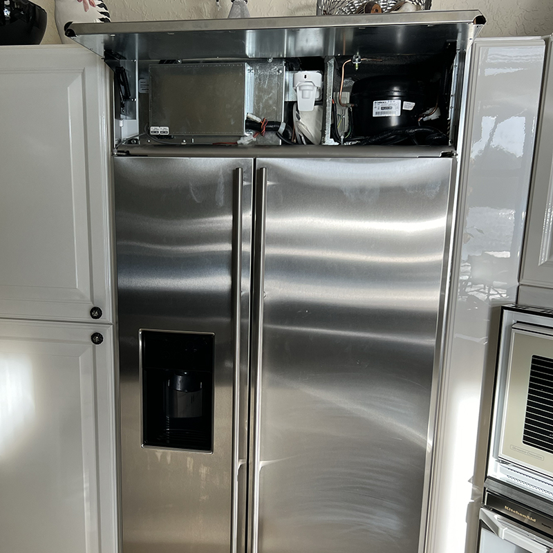 Refrigerator with visible internal components exposed, showcasing repair needs for Broward County appliance service and marine appliance repair context.