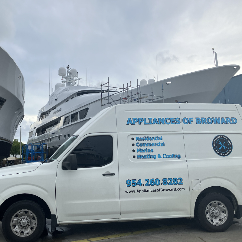 Appliances of Broward service van parked near large yachts, showcasing marine appliance repair services in Broward County.